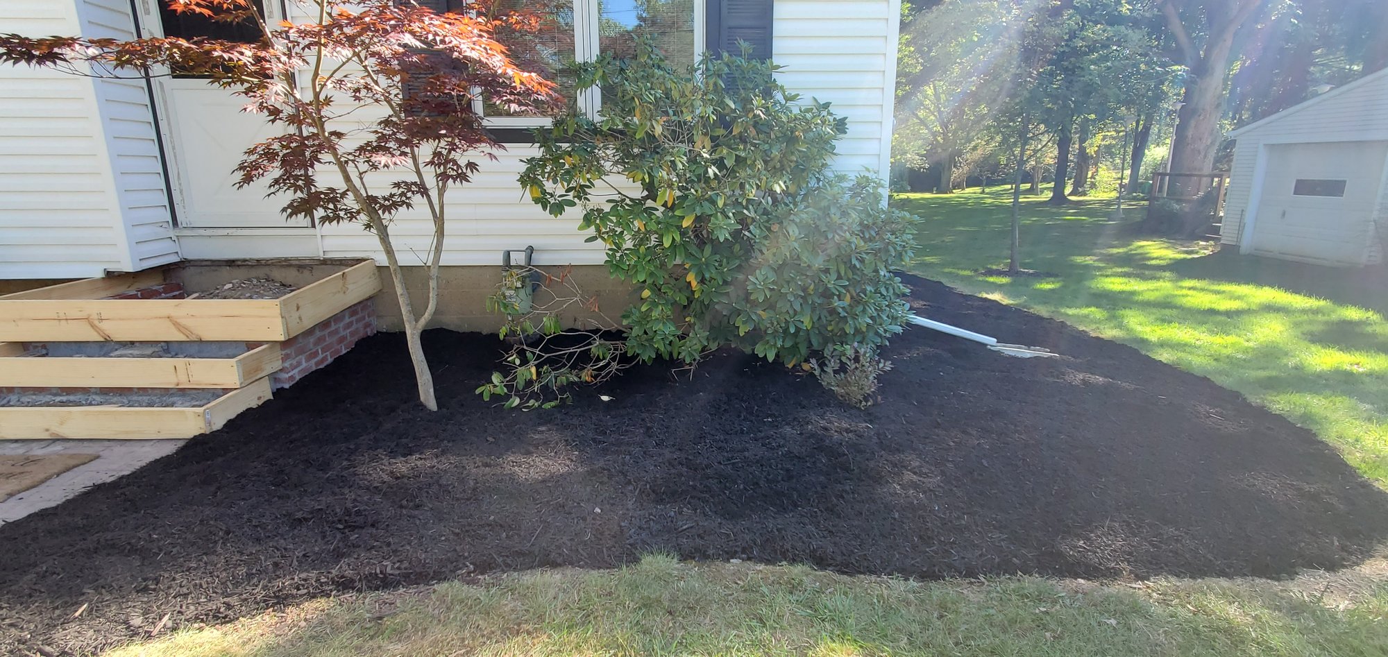 A front yard landscape bed with mulch installed and spread in Euclid, Oh from Kevin J Services
