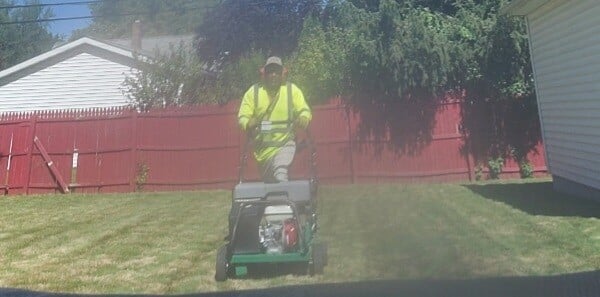 Aeration and overseeding being done in a Euclid, Ohio backyard by an employee at Kevin J Services
