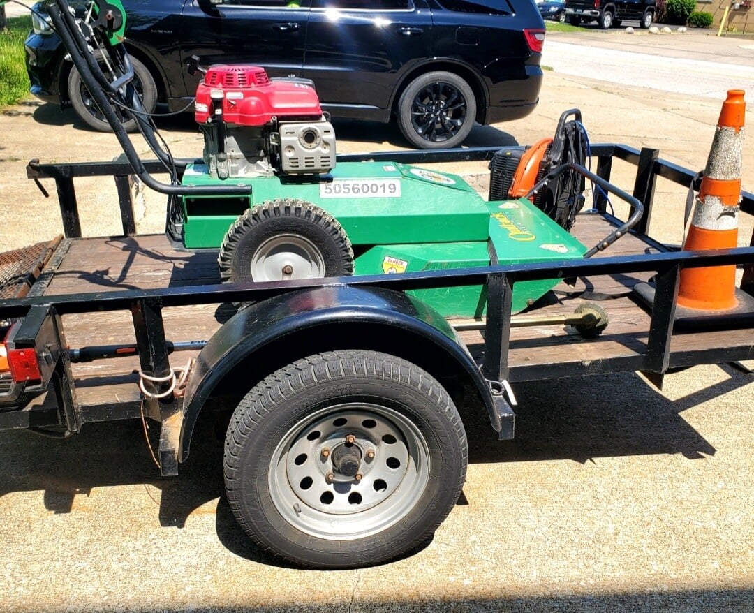 A brush cutter sit on the back of a trailer used by Kevin J Services before a job at a commercial building on Lakeview in Euclid, Ohio.