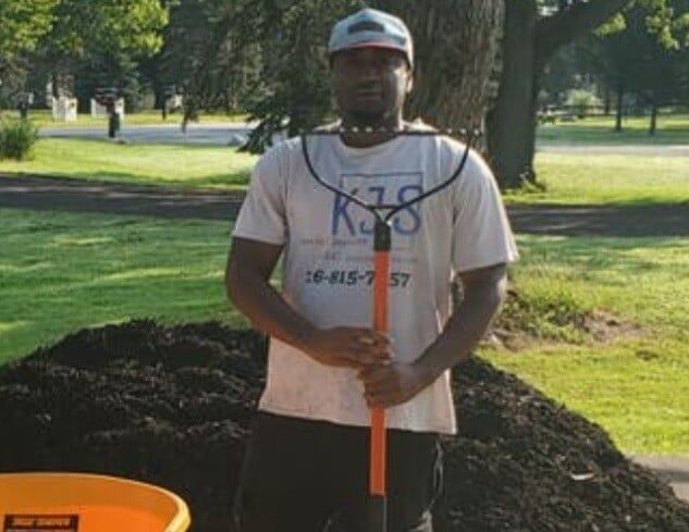 pile of mulch behind employee at a Northeast, Ohio home before being spread by Kevin J Services